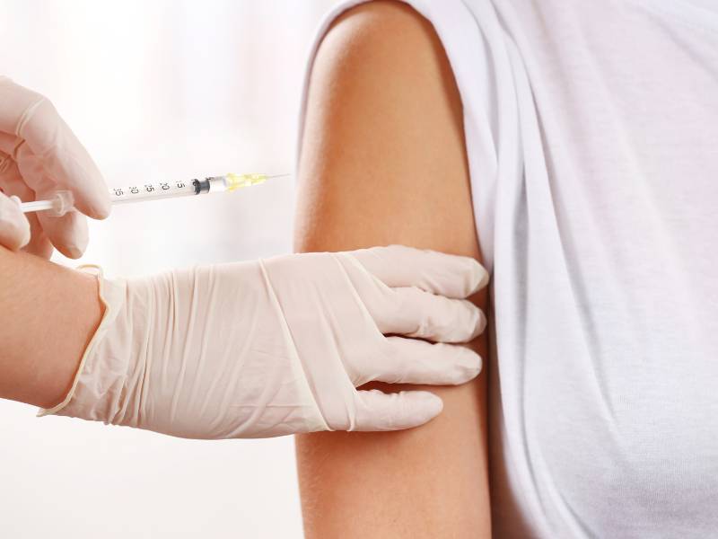 女性が子宮頸がんワクチンを接種している様子、看護師が腕に注射
