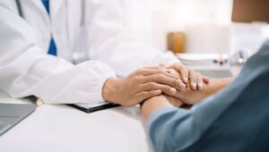 医師と患者が向き合い、手を重ねて安心感を伝える様子