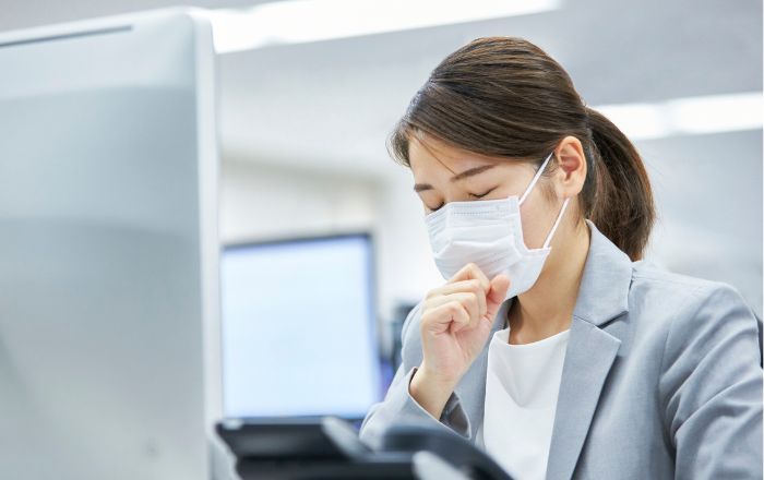 喉を押さえて咳き込む人物（アトピー咳嗽の症状イメージ）