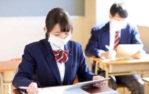 発熱後に登校した生徒が教室でマスクを着用して学習している様子