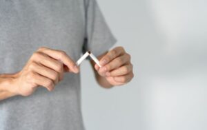 禁煙を決意しタバコを手で折って最後の一本にするイメージ